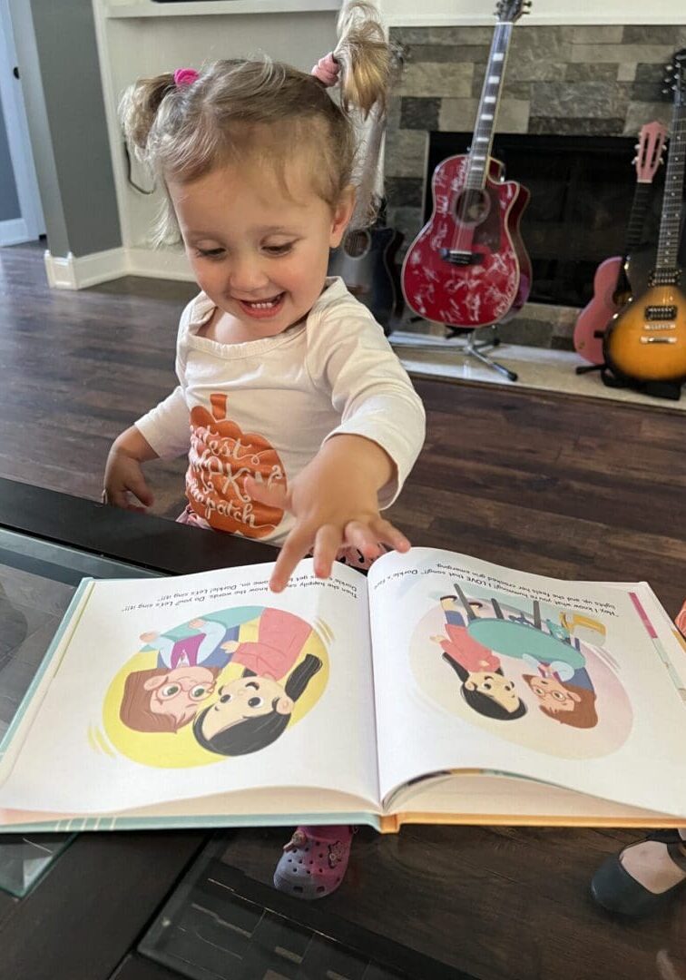 A baby is playing with an open book.